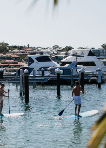 A couple of Pier 21 hotel guests paddleboard across the Swan River Image