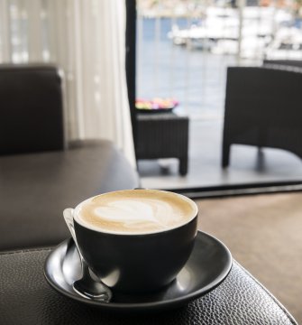 A cup of coffee on a leather couch in a hotel room