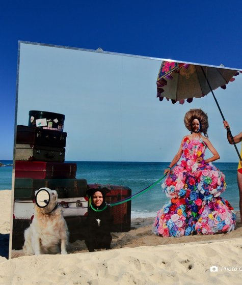 Sculpture on the beach that looks like a painting of a lifeguard holding an umbrella for a woman Image